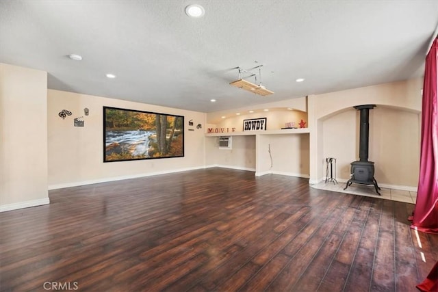 12963 Birch Glen Ct, Victorville, CA 92392 - unfurnished living room featuring dark wood-style floors, recessed lighting, a wood stove, and baseboards