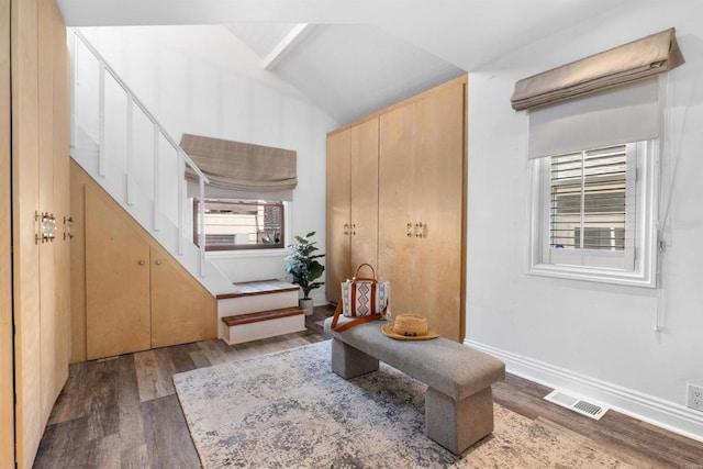 interior space featuring stairs, vaulted ceiling, baseboards, visible vents, and wood finished floors