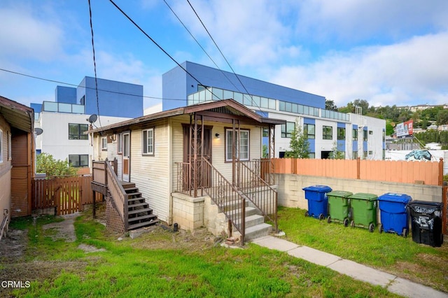 view of front of house with a front lawn and fence