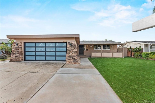 view of front of house featuring an attached garage, a front yard, concrete driveway, and stone siding