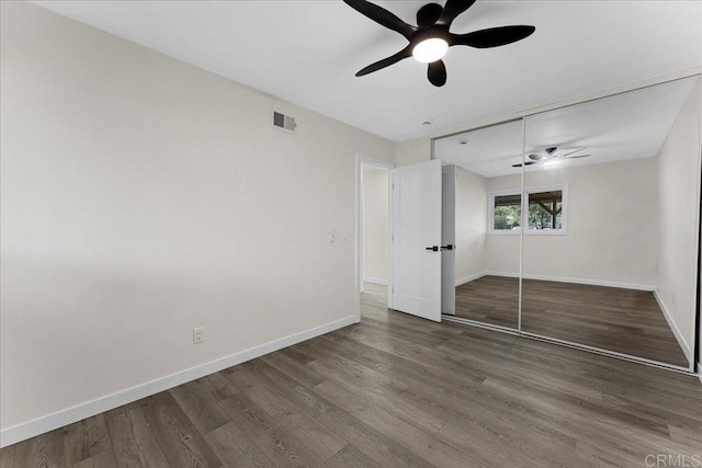 unfurnished bedroom with visible vents, wood finished floors, and baseboards