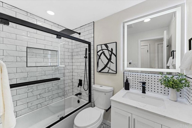 full bath featuring toilet, enclosed tub / shower combo, vanity, and decorative backsplash