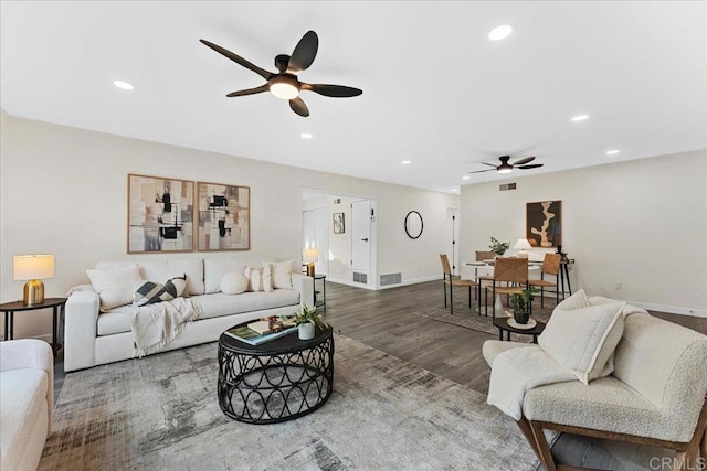 living area with wood finished floors, a ceiling fan, recessed lighting, and baseboards
