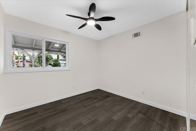 spare room featuring dark wood finished floors and baseboards
