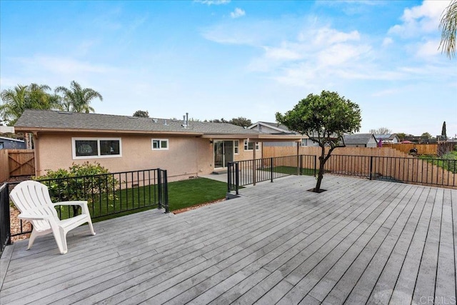 wooden terrace featuring a yard and a fenced backyard