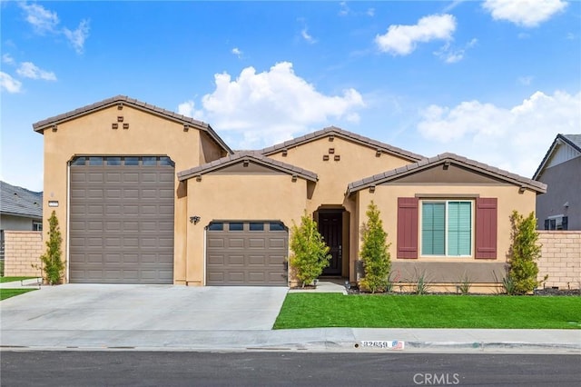 view of front facade featuring a tiled roof, an attached garage, fence, stucco siding, and driveway