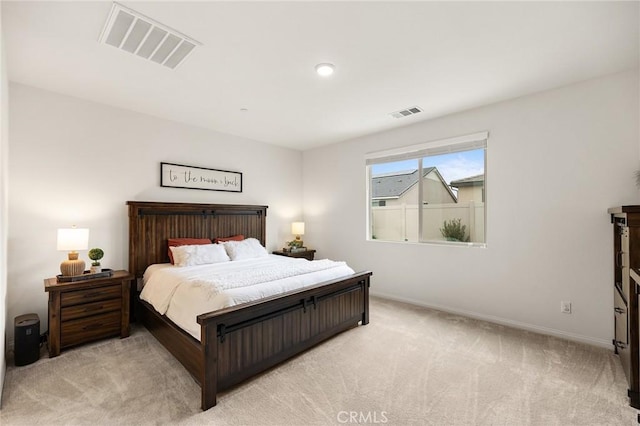 bedroom featuring visible vents, light colored carpet, and baseboards