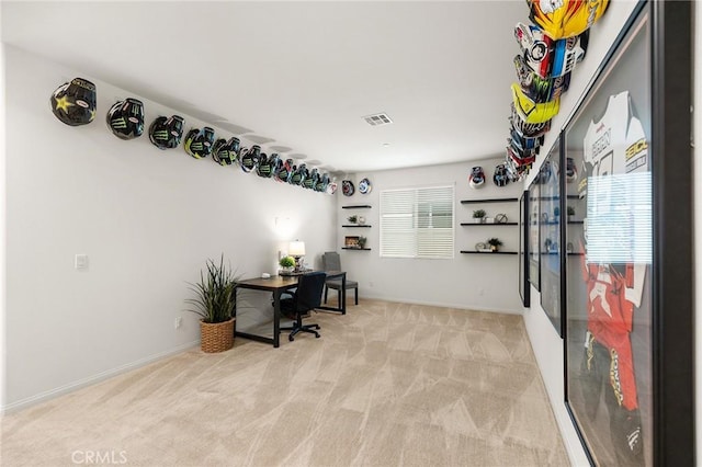 office with visible vents, baseboards, and light colored carpet