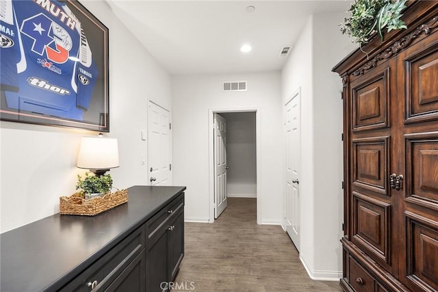 corridor featuring recessed lighting, visible vents, baseboards, and wood finished floors
