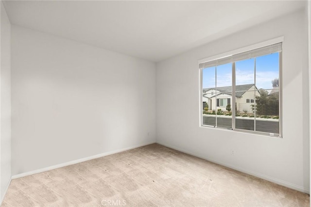 empty room with light carpet and baseboards