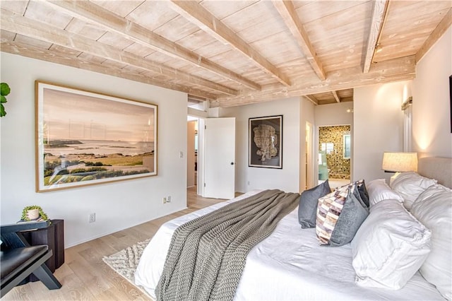 bedroom featuring beamed ceiling, wooden ceiling, wood finished floors, and ensuite bathroom