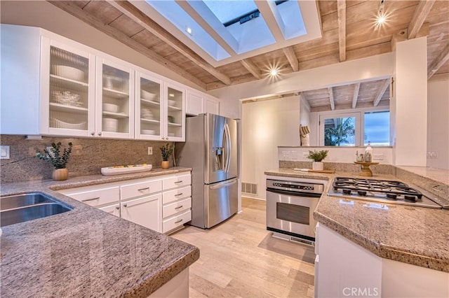 kitchen featuring light wood finished floors, appliances with stainless steel finishes, wooden ceiling, and light stone countertops