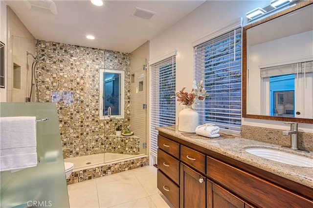 full bath featuring visible vents, tile patterned flooring, vanity, toilet, and tiled shower