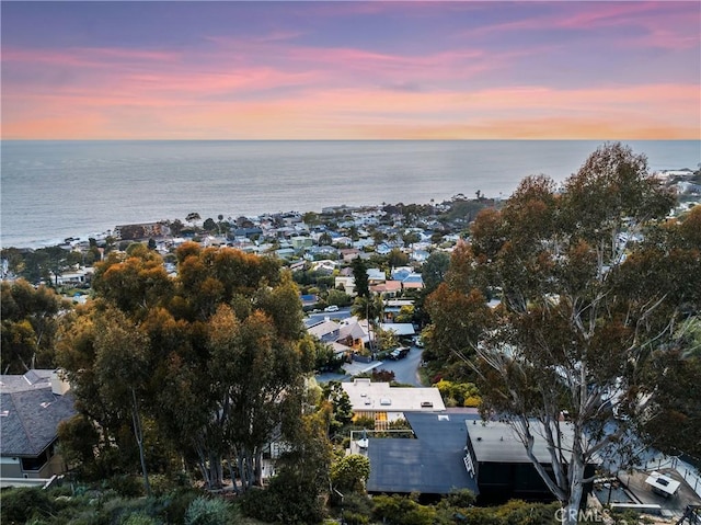 aerial view at dusk featuring a water view