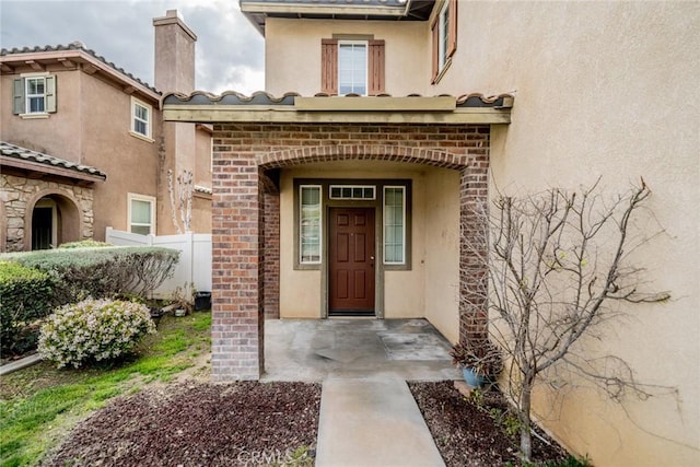 35317 Trevino Trl, Beaumont, CA 92223 - entrance to property with a tiled roof, brick siding, stucco siding, and a chimney