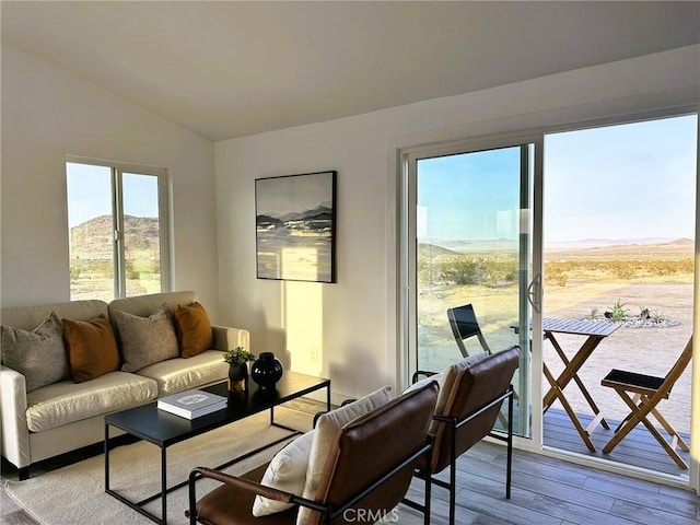 living area with vaulted ceiling, wood finished floors, and a mountain view