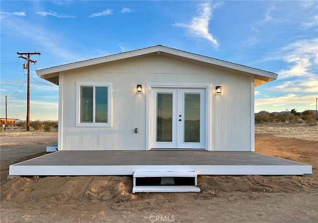 rear view of property with a wooden deck and french doors
