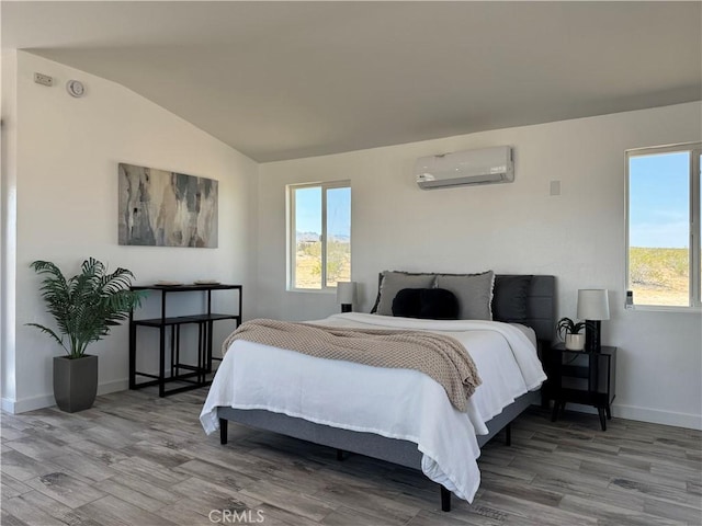 bedroom featuring lofted ceiling, wood finished floors, a wall unit AC, and multiple windows