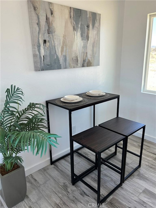 dining space with wood finished floors and baseboards