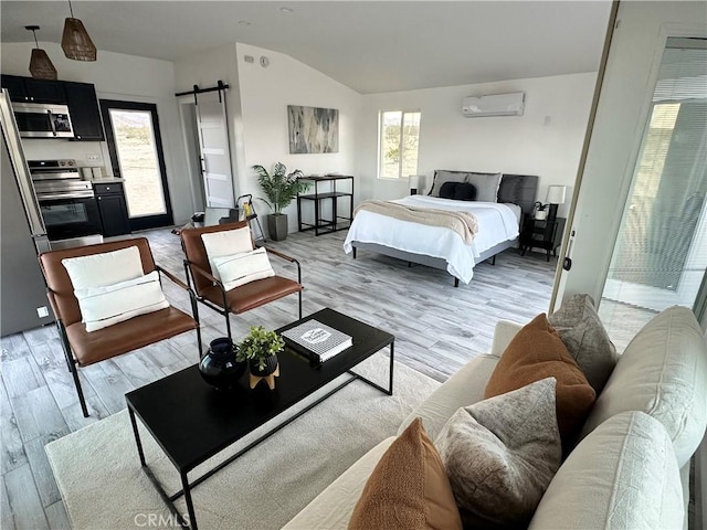 bedroom with lofted ceiling, multiple windows, light wood finished floors, and a wall unit AC
