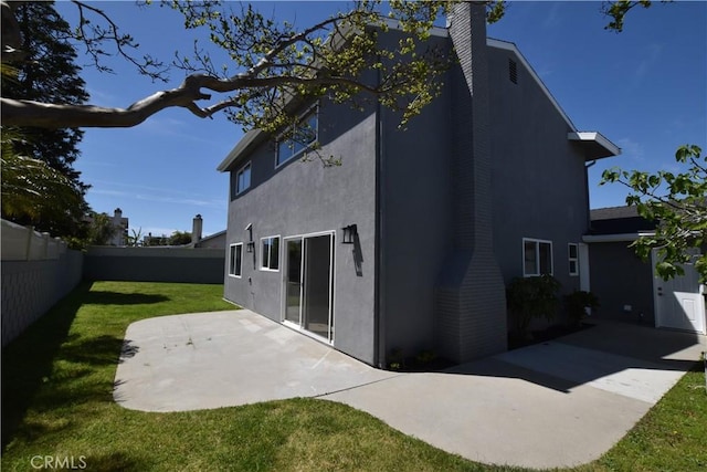 23408 Dorset Pl, Harbor City, CA 90710 - back of house with a chimney, a lawn, a fenced backyard, a patio, and stucco siding