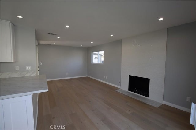 23408 Dorset Pl, Harbor City, CA 90710 - unfurnished living room featuring a large fireplace, light wood-style flooring, baseboards, and recessed lighting