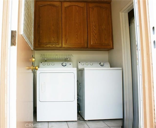 3724 W 105th St, Inglewood, CA 90303 - washroom featuring washing machine and dryer, light tile patterned flooring, and cabinet space