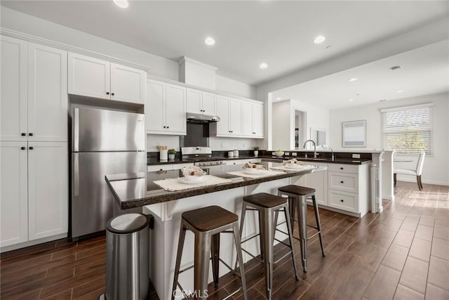 144 Borrego, Irvine, CA 92618 - kitchen featuring a peninsula, under cabinet range hood, stainless steel appliances, wood tiled floor, and white cabinets
