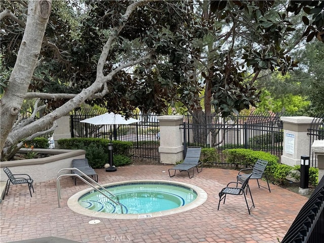 view of swimming pool with fence, a patio area, and a community hot tub
