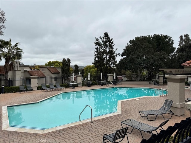 community pool featuring a patio area and fence