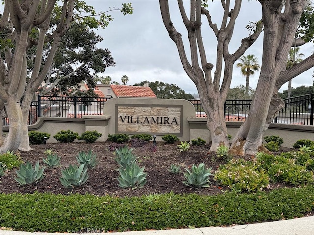 community / neighborhood sign featuring fence
