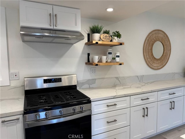 kitchen featuring light stone counters, white cabinetry, under cabinet range hood, gas stove, and recessed lighting