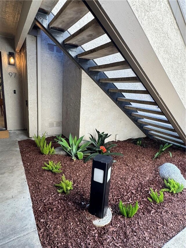 exterior space with stairway and stucco siding