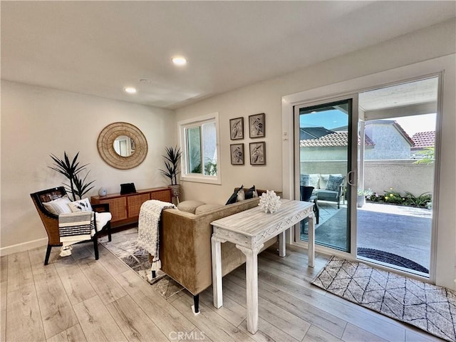 living area featuring light wood-type flooring, baseboards, and recessed lighting