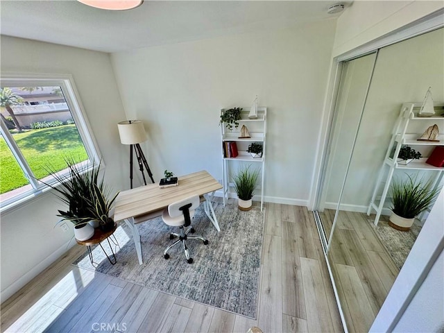 home office with baseboards and wood finished floors