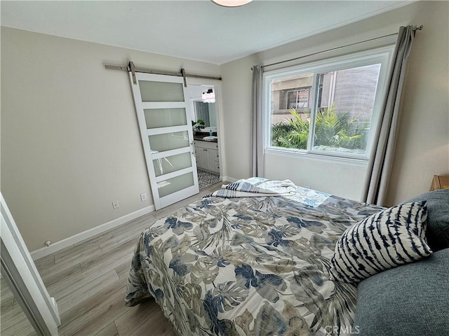 28181 Sorrento Unit 97, Laguna Niguel, CA 92677 - bedroom featuring wood finished floors, a barn door, baseboards, and ensuite bath