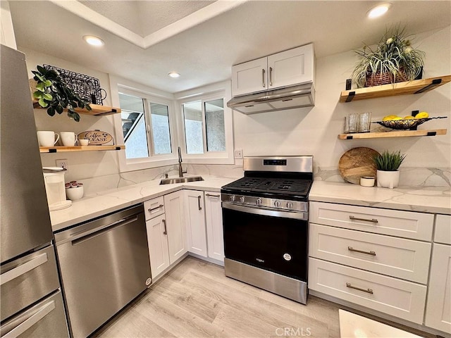 28181 Sorrento Unit 97, Laguna Niguel, CA 92677 - kitchen featuring stainless steel appliances, a sink, under cabinet range hood, open shelves, and light wood-style floors