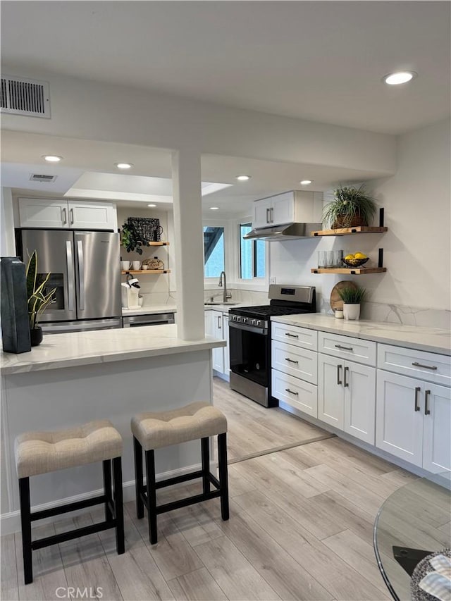28181 Sorrento Unit 97, Laguna Niguel, CA 92677 - kitchen with stainless steel appliances, open shelves, a breakfast bar area, a sink, and recessed lighting