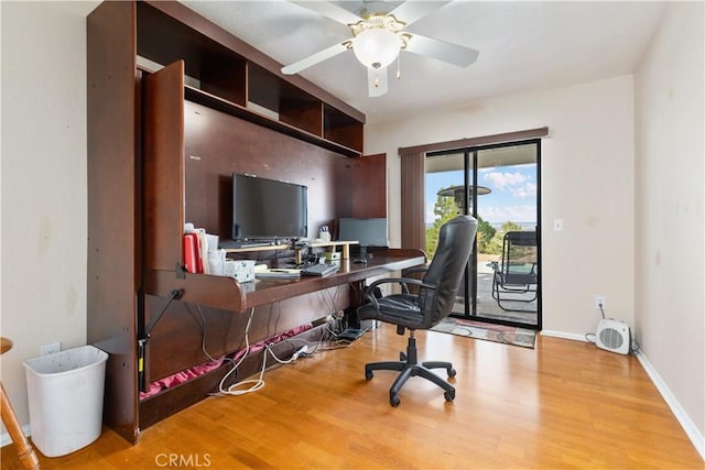 office area with a ceiling fan, baseboards, and wood finished floors