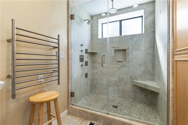 full bathroom with baseboards, radiator heating unit, tile patterned floors, and a stall shower