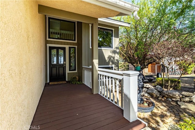 view of exterior entry featuring stucco siding and a porch