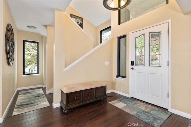 foyer with baseboards, lofted ceiling, stairway, and dark wood-style flooring