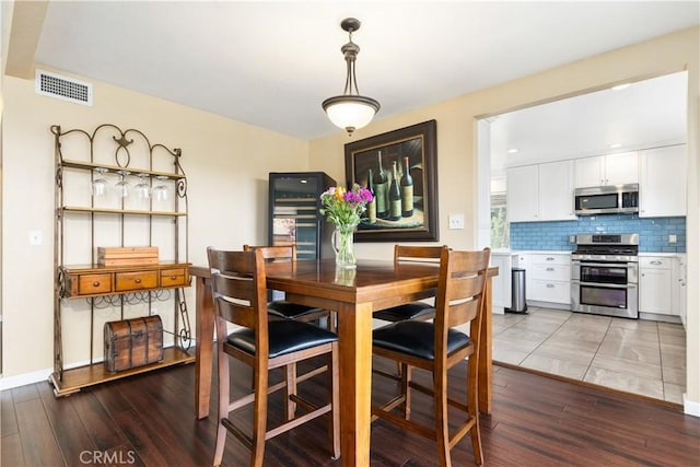 dining space featuring baseboards, visible vents, and wood finished floors