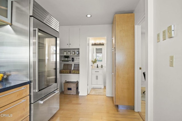 1414 Meadowbrook Rd, Ojai, CA 93023 - kitchen with stainless steel built in refrigerator, light wood-type flooring, dark countertops, recessed lighting, and white cabinetry