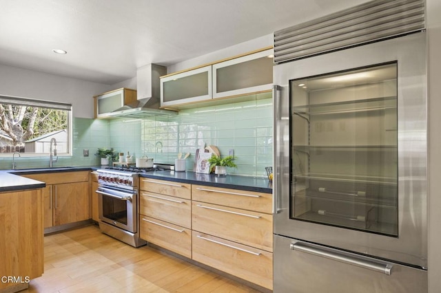 1414 Meadowbrook Rd, Ojai, CA 93023 - kitchen with high end appliances, light wood-style flooring, wall chimney exhaust hood, backsplash, and glass insert cabinets