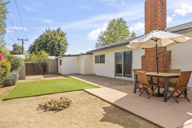 1414 Meadowbrook Rd, Ojai, CA 93023 - rear view of house featuring stucco siding, fence, a patio area, a chimney, and outdoor dining space