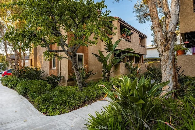 view of front facade featuring stucco siding and fence