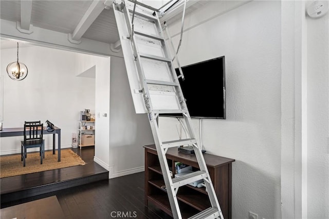 interior space featuring dark wood-style floors, beamed ceiling, baseboards, and a chandelier