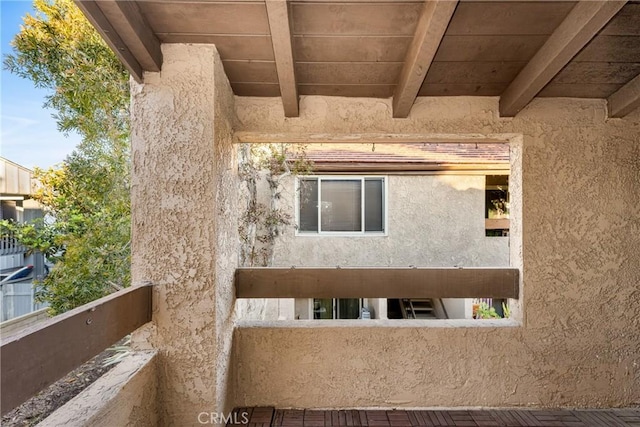 view of side of property featuring a balcony and stucco siding