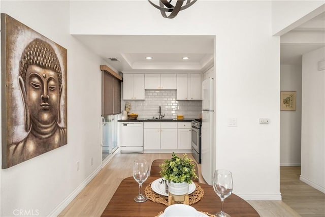 kitchen featuring backsplash, a sink, stainless steel gas range, dishwasher, and white cabinets